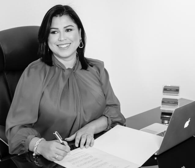 Mulher em uma mesa assinando documento