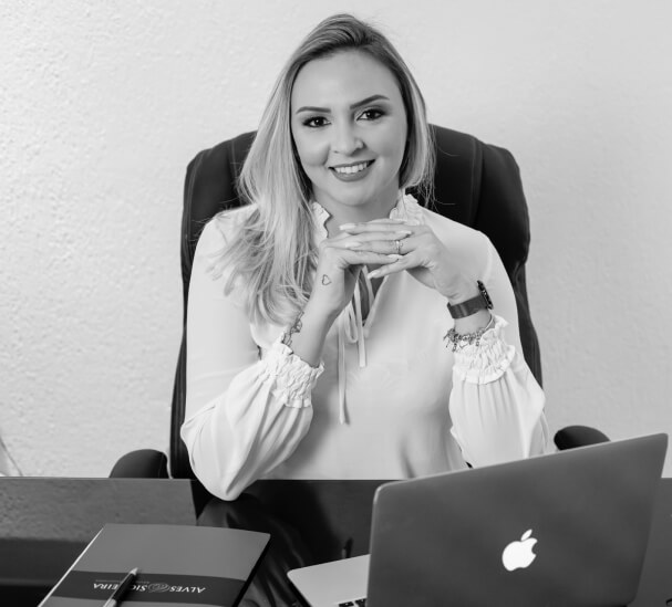 advogada com sentada em uma mesa com computador macbook air